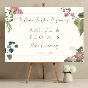 Personalised Roka Ceremony welcome sign printed on 3mm Foamex 
on a wooden easel, soft pink botanical wild roses and eucalyptus 
on warm ivory background, custom names Rahul and Pooja in elegant 
spaced serif and calligraphy typography, A1 landscape format