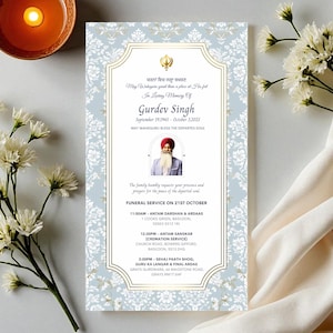 Puede incluir: Tarjeta conmemorativa con borde de patrón floral azul claro, detalles dorados y texto. La tarjeta incluye una foto de un hombre y detalles de un servicio funerario. Flores blancas y una vela rodean la tarjeta.