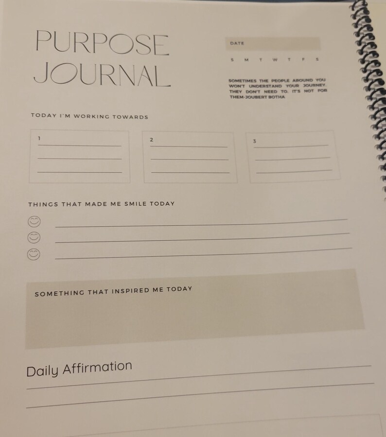 K&ouml;nnte beinhalten: Ein wei&szlig;es Journal mit den Worten "Purpose Journal" oben. Das Journal hat Abschnitte f&uuml;r t&auml;gliche Affirmationen, Dinge, die dich heute zum L&auml;cheln gebracht haben, und etwas, das dich heute inspiriert hat. Es hat auch einen Abschnitt, um drei Dinge aufzuschreiben, auf die du hinarbeitest.