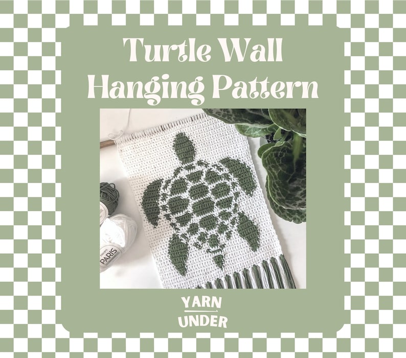 May include: A green crocheted turtle wall hanging with white yarn. The hanging has a fringe at the bottom and the text "YARN UNDER" is printed below the turtle.