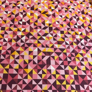 May include: A fabric with a repeating geometric pattern of triangles in shades of pink, yellow, white, and burgundy. The triangles are arranged in a mosaic-like design, creating a visually dynamic surface.