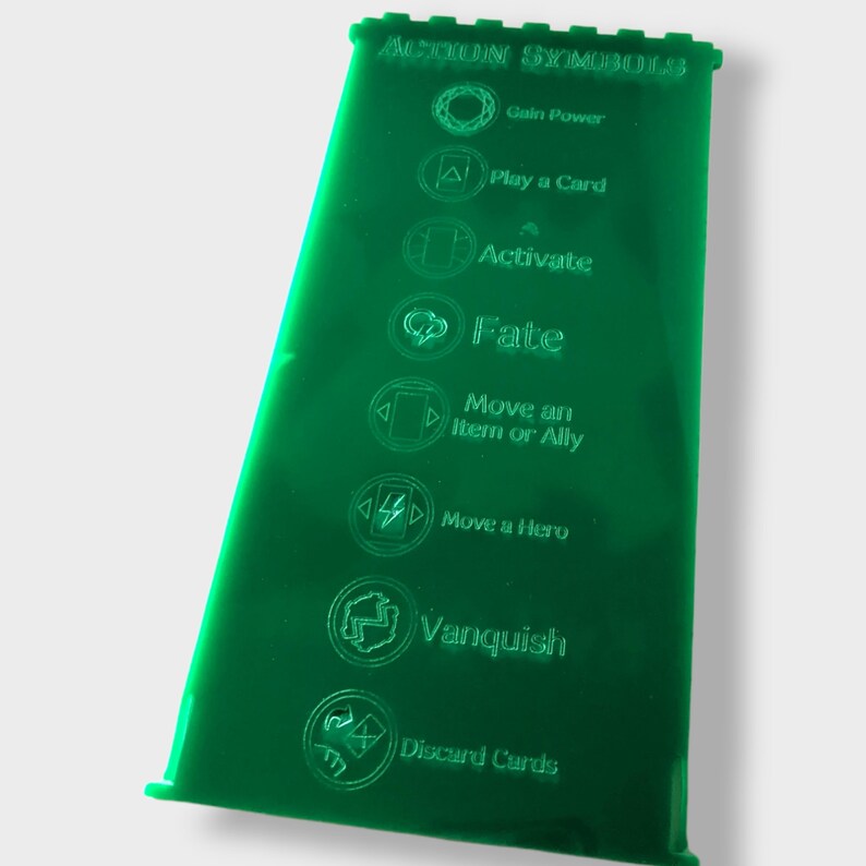 Pu&ograve; includere: Foglio di acrilico verde con simboli di azione incisi per un gioco da tavolo. I simboli includono: Guadagnare potere, Giocare una carta, Attiva, Destino, Spostare un oggetto o un alleato, Spostare un eroe, Vincere e Scartare carte.