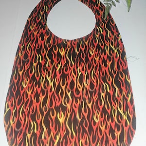 May include: A black bib with a flame pattern in shades of red, orange, and yellow. The bib has a rounded neck opening.