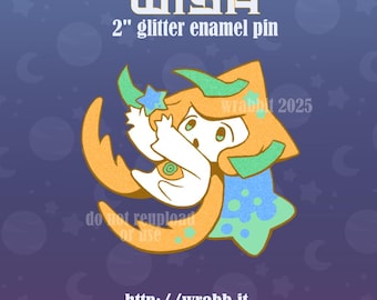 May include: A 2-inch glitter enamel pin featuring a stylized character with orange hair and a white body, positioned against a blue star-shaped background. The text WISH and 2" glitter enamel pin are printed above the character, with the URL http://wrabb.it below.