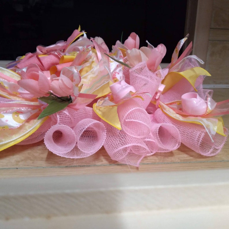 A rare find and one of a kind. A baby shower wreath for a little girl with pink booties and rattlers. Plastic rocking horses and baby bottle image 4