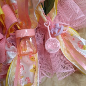 A rare find and one of a kind. A baby shower wreath for a little girl with pink booties and rattlers. Plastic rocking horses and baby bottle image 7