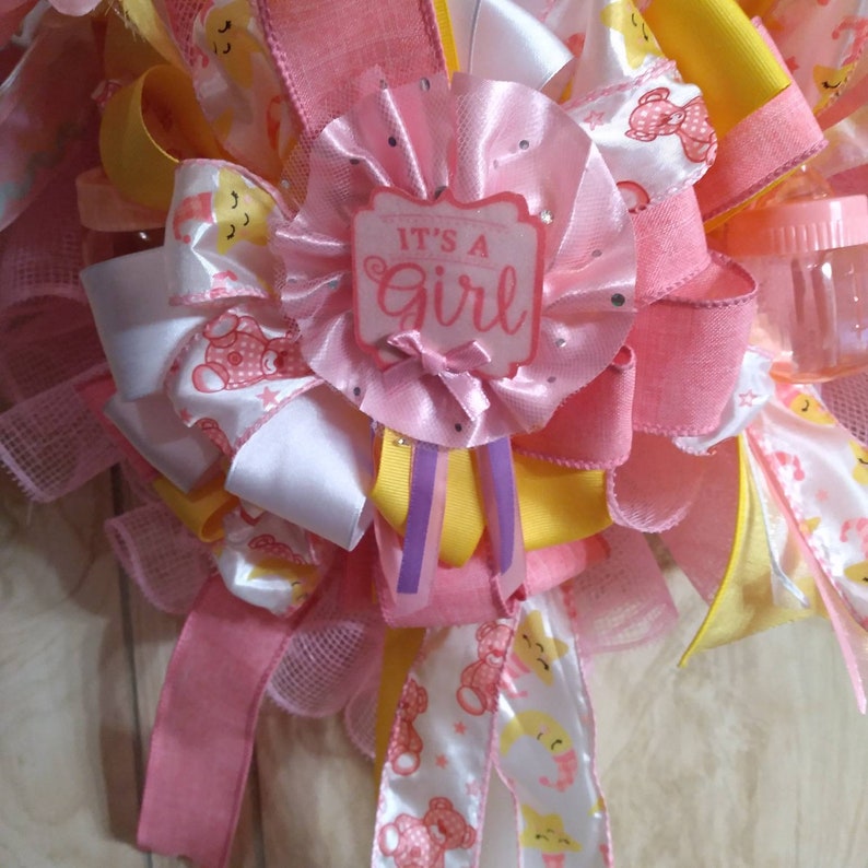 A rare find and one of a kind. A baby shower wreath for a little girl with pink booties and rattlers. Plastic rocking horses and baby bottle image 8