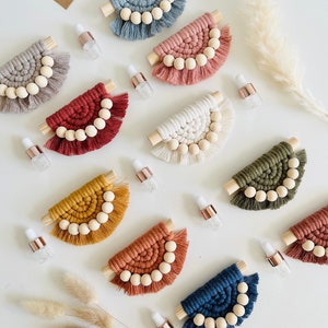 May include: Assortment of 10 colorful macrame wall hangings with wooden beads and tassels. Each hanging is a half-circle shape with a wooden dowel at the top. The hangings are in various colors, including blue, pink, red, white, yellow, orange, and green.