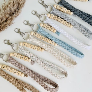 May include: A set of nine keychains with braided cords and wooden beads spelling out names, including Jessie, Ruby, Carole, Joe, Cassie, Elsie, June, and Chloe.