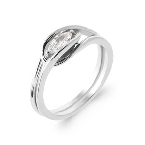 May include: A silver ring with a single, clear, marquise-shaped gemstone set in a unique, twisted band.