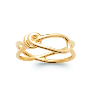 May include: A gold ring with a twisted knot design.