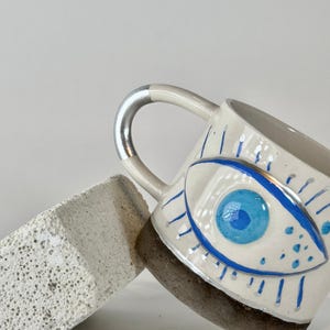 Handmade Evil eye ceramic coffee mug with handle.