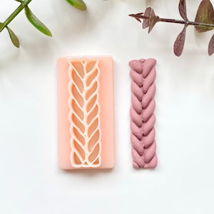 Puede incluir: Un molde de silicona para crear un diseño trenzado, mostrado junto a una muestra del producto terminado en color rosa polvoriento.