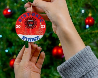 Personaliza tu número local en un adorno de cerámica histórico de la Huelga de la UAW de 2023. Opciones: A) Árboles de Navidad luminosos, B) Barriles de fuego únicos.