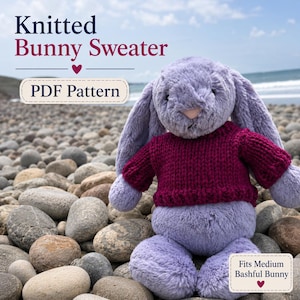 Könnte beinhalten: Ein lavendelfarbenes Plüschhasen-Stofftier, das einen dunkelmagentafarbenen Strickpullover trägt. Der Text auf dem Bild lautet Knitted Bunny Sweater, PDF Pattern und Fits Medium Bashful Bunny. Der Hase hat lange Ohren und ein weiches Fell.