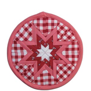 May include: A round red and white gingham fabric pot holder with a pink star in the center. The star is made of smaller pieces of fabric in red, white, and pink.