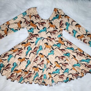 May include: A long-sleeved dress featuring a beige background with a repeating pattern of brown and teal horses. The dress has a scoop back and a flared skirt with a scalloped hem. The sleeves are long and fitted.