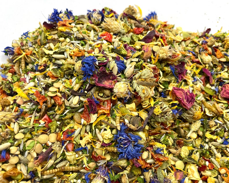 Pu&ograve; includere: Primo piano di un mix colorato di erbe, fiori e semi secchi. Il mix include petali di rosa secchi, fiordalisi, lenticchie e semi di girasole.