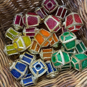 May include: A collection of colourful, glass, decorative lanterns with gold trim. The lanterns are in a wicker basket.
