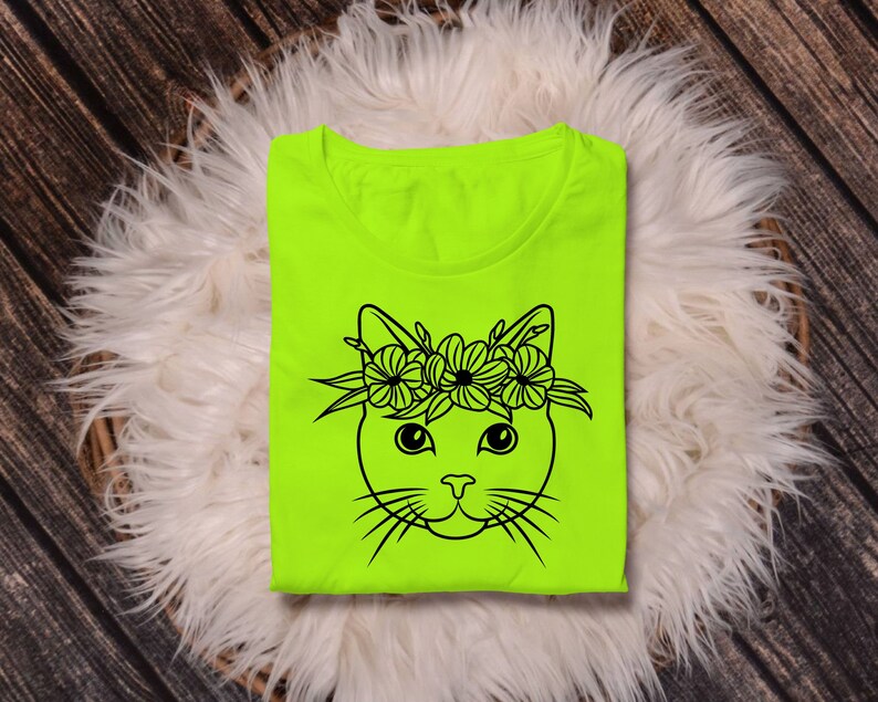May include: A neon green t-shirt with a black line drawing of a cat wearing a flower crown.