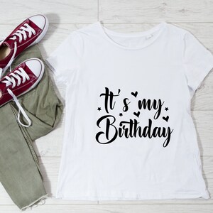 K&ouml;nnte beinhalten: Wei&szlig;es T-Shirt mit schwarzem Text, der "It's my Birthday" mit kleinen Herzen und Sternen um den Text herum sagt.