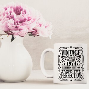 May include: White ceramic coffee mug with a black graphic that says "Vintage Premium Quality 1974 Limited Edition Aged to Perfection".