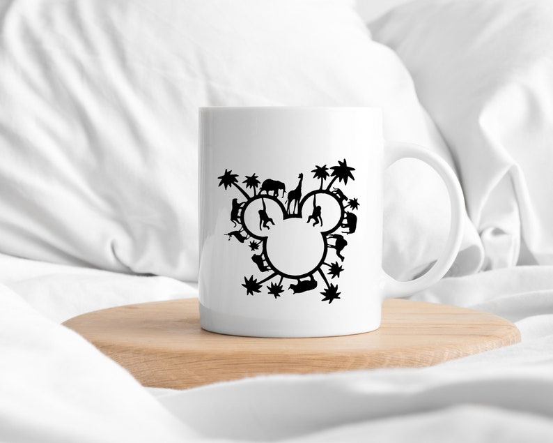 May include: White ceramic mug with a black silhouette of Mickey Mouse's head formed by various animals and palm trees.