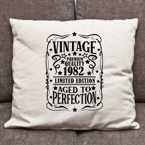 May include: White throw pillow with black text that reads "Vintage Premium Quality 1982 Limited Edition Aged to Perfection".