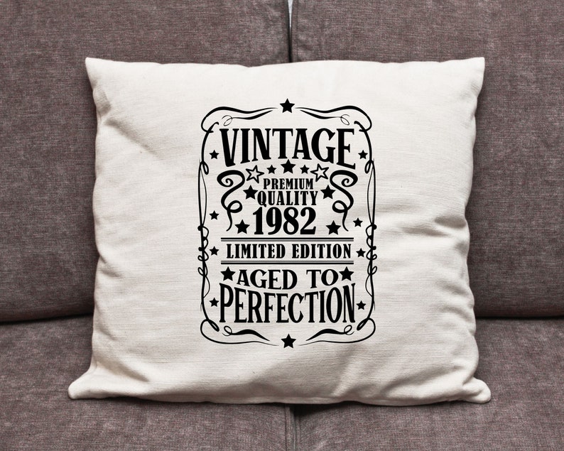 May include: White throw pillow with black text that reads "Vintage Premium Quality 1982 Limited Edition Aged to Perfection".