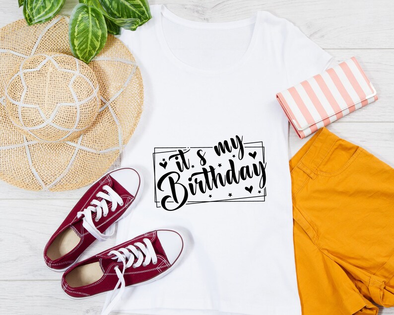 K&ouml;nnte beinhalten: Wei&szlig;es T-Shirt mit schwarzem Text, der "It's my Birthday" in einer dekorativen Schriftart mit Herzen und Sternen um den Text herum sagt.