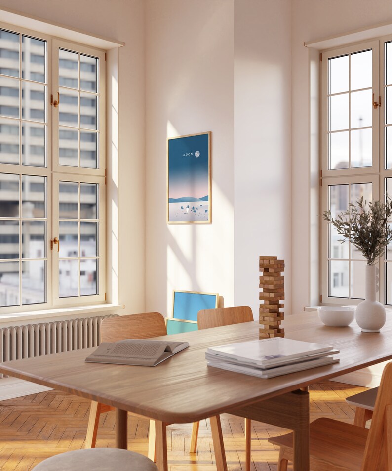 K&ouml;nnte beinhalten: Ein Esstisch aus Holz mit einer hellen Holzoptik. Auf dem Tisch liegen ein Stapel B&uuml;cher und ein Turm aus Holzkl&ouml;tzen. Es gibt vier St&uuml;hle um den Tisch herum, von denen zwei auf dem Bild zu sehen sind. Der Tisch steht in einem Raum mit gro&szlig;en Fenstern und einem gerahmten Druck an der Wand.