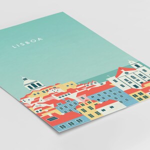 May include: A print featuring a stylized illustration of Lisbon, Portugal. The artwork depicts a cityscape with red-tiled roofs, blue and yellow buildings, and a light blue sky. The word "LISBOA" is printed in white at the top.