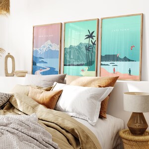 May include: Three framed illustrations of different locations. The first illustration is of New Zealand with a mountain range and a winding road. The second illustration is of Hawaii with palm trees and a beach. The third illustration is of Cape Town with a mountain and a kite surfer.