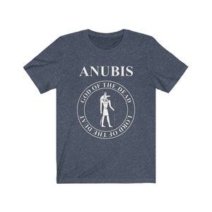 Op de afbeelding: Een marineblauw t-shirt met een witte afbeelding van Anubis, de Egyptische god van de dood. De afbeelding bevat de tekst "God van de Doden" en "Heer van de Duat".