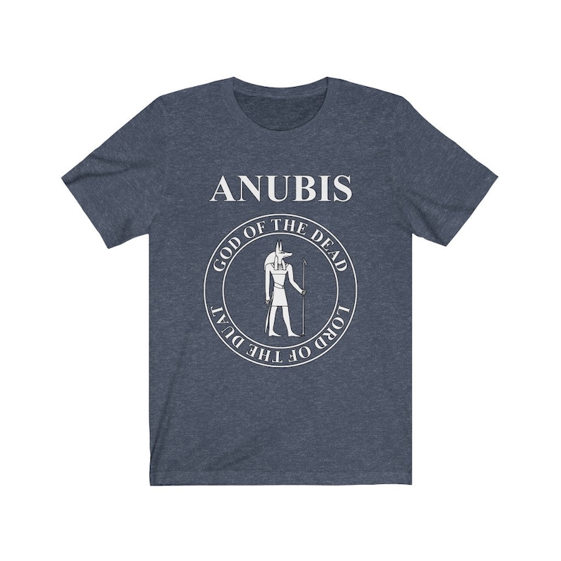 Op de afbeelding: Een marineblauw t-shirt met een witte afbeelding van Anubis, de Egyptische god van de dood. De afbeelding bevat de tekst "God van de Doden" en "Heer van de Duat".