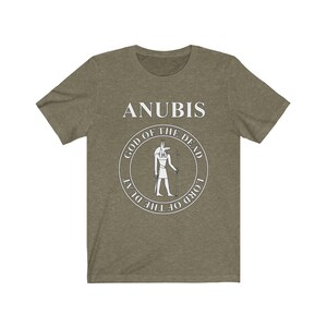 Op de afbeelding: Een groen T-shirt met een wit cirkelvormig ontwerp met de Egyptische god Anubis. De cirkel bevat de tekst "God van de Doden" en "Heer van de Duat".