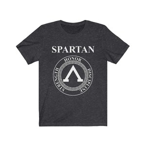 May include: A dark heather grey t-shirt with a white Spartan logo. The logo features a shield with the words "Honor, Strength, Discipline" around it.