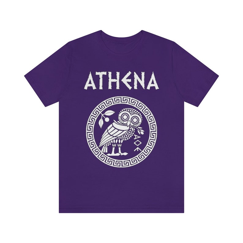 May include: Purple t-shirt with a white graphic of an owl inside a circle with a Greek key border. The text "ATHENA" is above the owl.