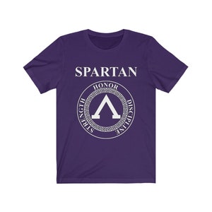 May include: Purple short-sleeved t-shirt with a white graphic of a Spartan helmet with the words "SPARTAN" and "HONOR, STRENGTH, DISCIPLINE" around it.