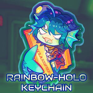 May include: A rainbow holo keychain with a cartoon character with blue hair and teal fins, holding a "Classified" document. The keychain has a shark tail design and the text "Rainbow-Holo Keychain".