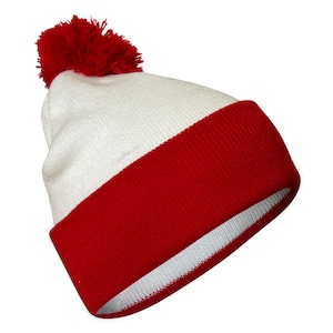 May include: White beanie with a red pom pom and a red band around the bottom.