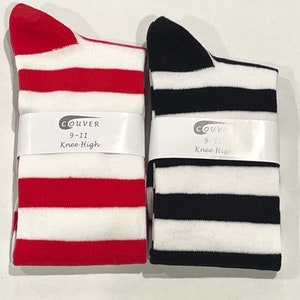 May include: Two pairs of knee-high socks with white stripes. One pair is red and white, the other is black and white. Both pairs have a label that says "Couvre 9-11 Knee High".