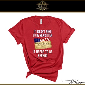 May include: Red t-shirt with a white graphic print of the US Constitution with the text "It doesn't need to be rewritten. We the People. It needs to be reread."