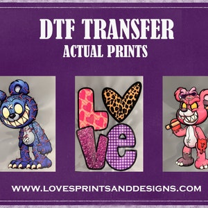 May include: Three DTF transfers featuring a blue teddy bear with stitches and a toothy grin, a pink teddy bear with stitches and a toothy grin holding a baseball bat, and a purple and pink "LOVE" graphic with glitter and hearts. The transfers are on a purple background with the text "DTF TRANSFER ACTUAL PRINTS" and "WWW.LOVESPRINTSANDDESIGNS.COM".