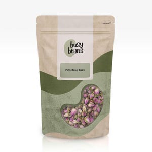 May include: A stand-up pouch with a beige and sage green abstract pattern. The label features the text "busy beans" and "Pink Rose Buds". A clear, kidney-shaped window at the bottom reveals a collection of dried pink rose buds inside the bag.