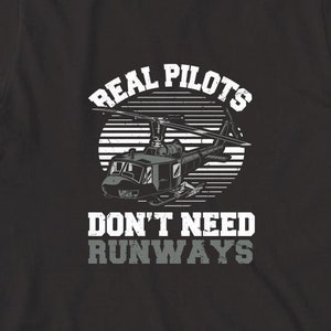 May include: Black t-shirt with a white graphic of a helicopter and the text "Real Pilots Don't Need Runways".
