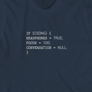 Puede incluir: Una camiseta azul marino con texto blanco que dice: "IF (CODING) { HEADPHONES = TRUE; FOCUS = 100; CONVERSATION = NULL; }"