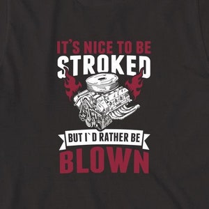 May include: Black t-shirt with a red graphic of a car engine and the text "It's nice to be stroked but I'd rather be blown".