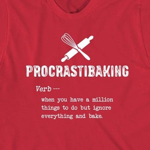 May include: Red t-shirt with a white graphic that says "PROCRASTIBAKING" and defines it as a verb: "when you have a million things to do but ignore everything and bake."