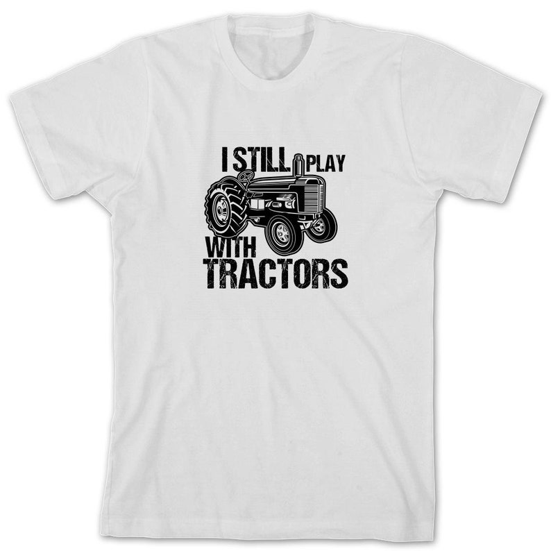 May include: White t-shirt with a black and white illustration of a tractor and the text "I Still Play With Tractors".